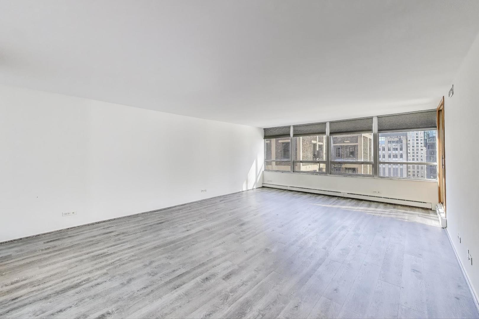 201 East Chestnut Street, Unit 19F Chicago, IL 60611 - Photo 10 of 36 an empty room with wooden floor and windows