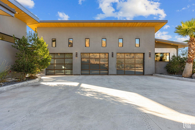 3652 South Cypress Road Hurricane, UT 84737 - Photo 64 of 81 Modern exterior featuring a stucco finish, three transparent garage doors, and linear windows