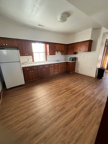 a view of a kitchen with wooden floor and electronic appliances