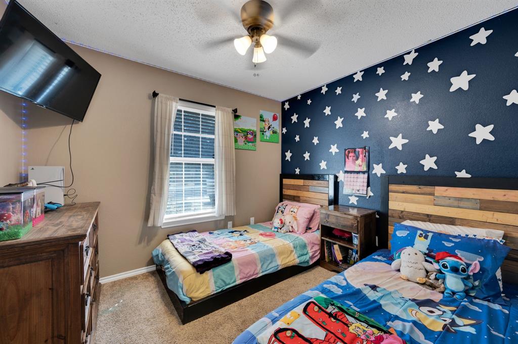 1003 Short Line Boulevard Midlothian, TX 76065 - Photo 20 of 25 Bedroom featuring an accent wall, carpet floors, a textured ceiling, and a ceiling fan