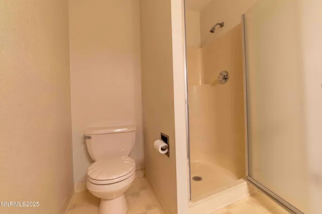 a bathroom with a toilet and a shower