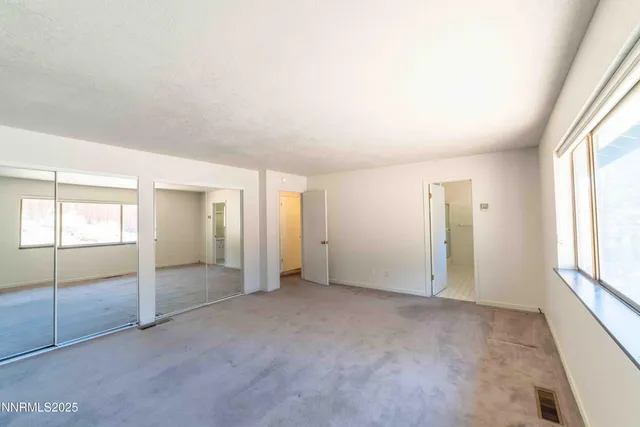 an empty room with windows and closet