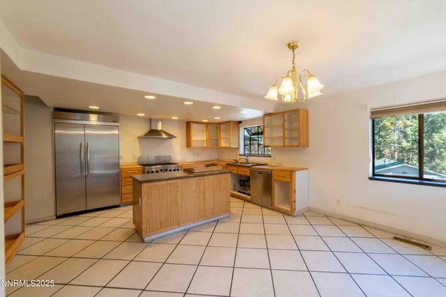 a large kitchen with granite countertop a stove a sink a counter space and cabinets