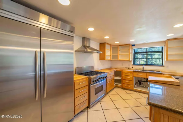 a kitchen with stainless steel appliances granite countertop a refrigerator and a stove
