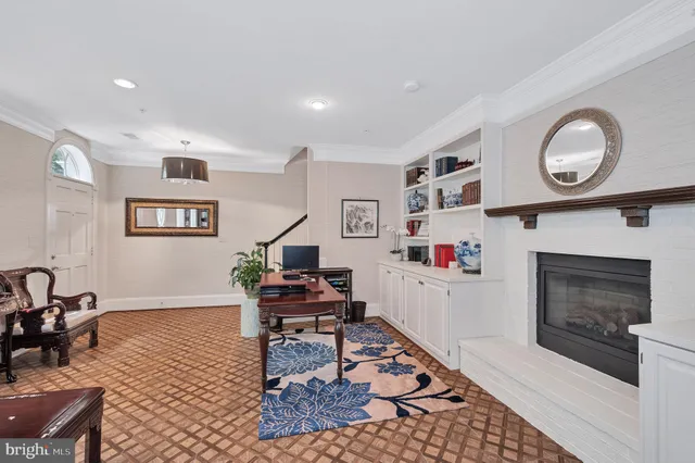 a living room with stainless steel appliances furniture wooden floor and a large window
