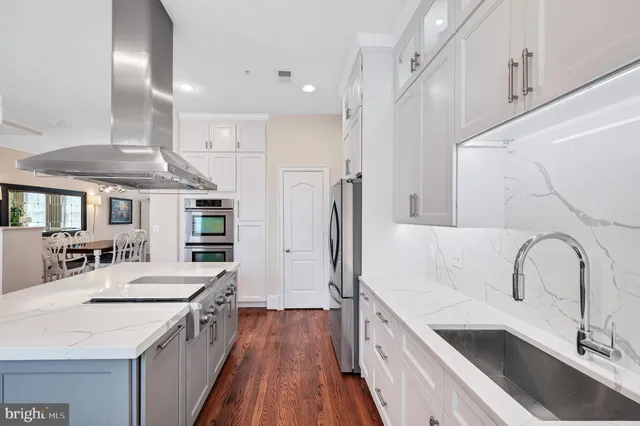 a kitchen with stainless steel appliances granite countertop a sink a stove and a refrigerator
