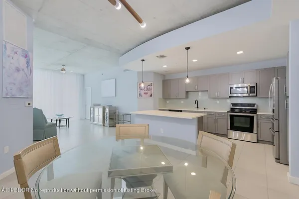a large white kitchen with lots of counter space and furniture
