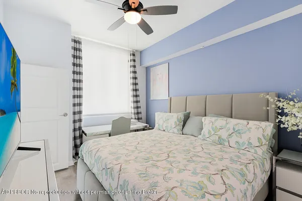 a bedroom with a large bed and a chandelier