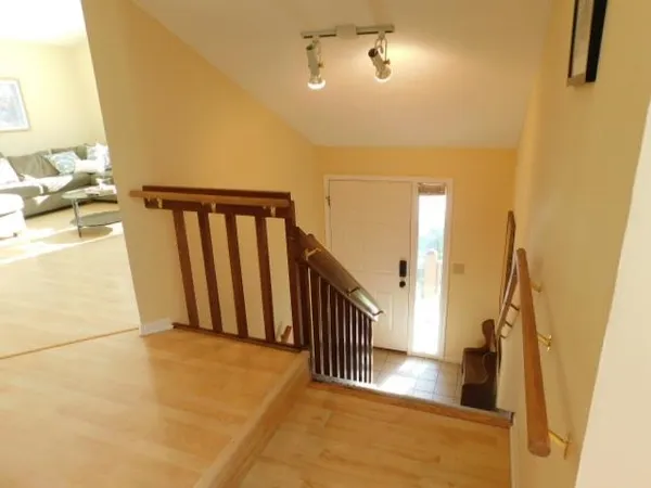 a view of entryway and hall with wooden floor