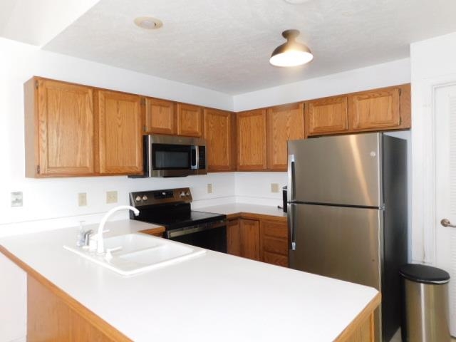 524 Triton Avenue Rockford, IL 61107 - Photo 9 of 18 a kitchen with a sink a microwave a refrigerator and cabinets