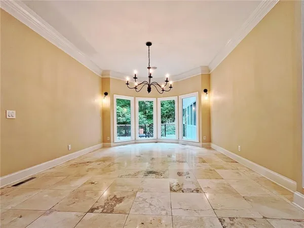 an empty room with wooden floor fireplace and windows