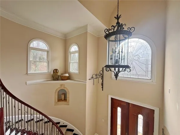 a view of a hallway with windows and chandelier