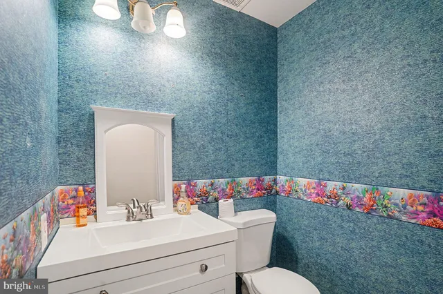 a bathroom with a sink vanity mirror and toilet