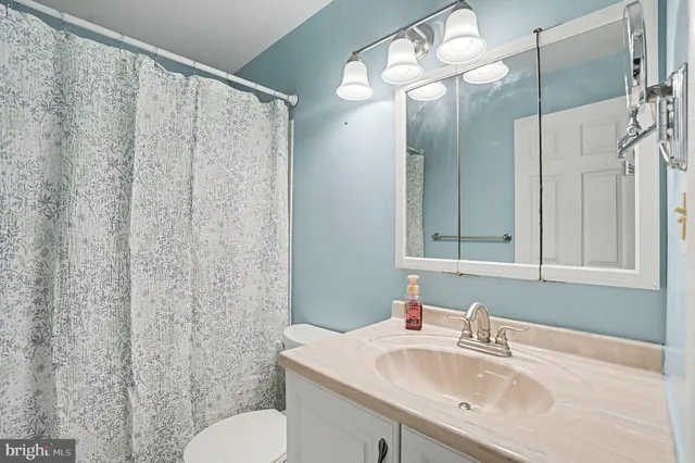a bathroom with a sink vanity mirror and toilet