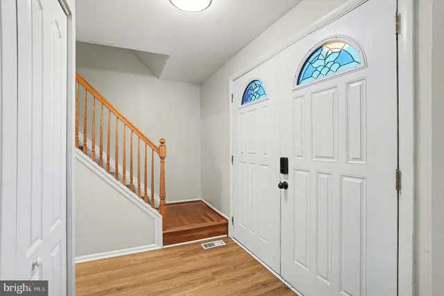 a view of hallway with stairs and wooden floor