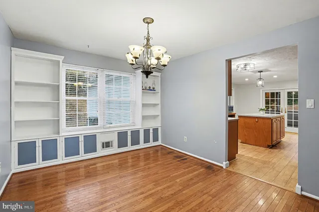 a view of a room with wooden floor and chandelier