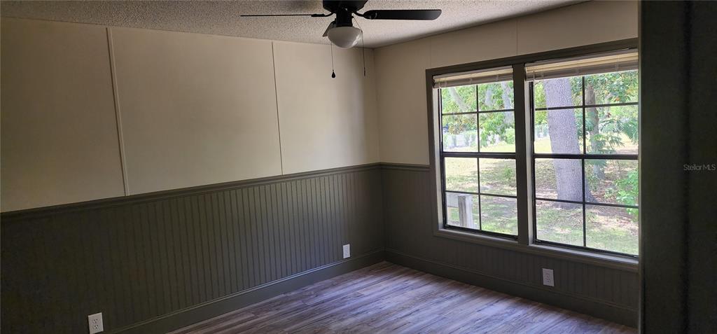 19865 Southwest 5th Place Dunnellon, FL 34431 - Photo 59 of 78 an empty room with wooden floor a ceiling fan and windows