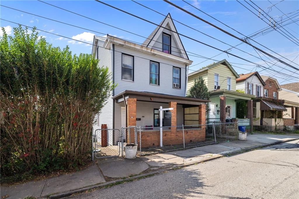 2312 Spring Street Pittsburgh, PA 15210 - Photo 2 of 29 a front view of a residential apartment building with a yard