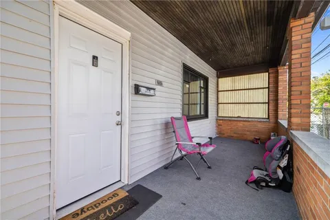 a view of a livingroom with lounge chair and windows