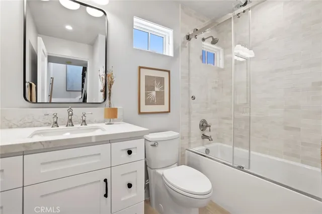 a bathroom with a granite countertop toilet sink and a mirror