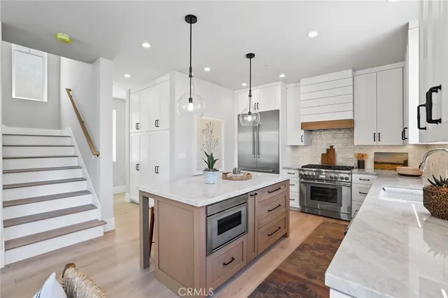 a kitchen with a stove a sink a refrigerator and cabinets