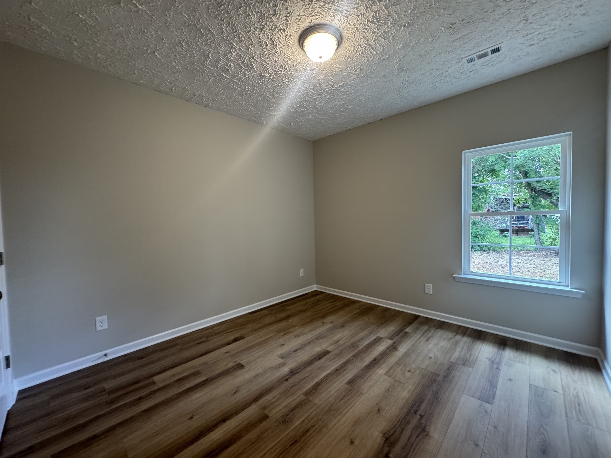 69 Laurel View Street Manchester, TN 37355 - Photo 11 of 15 an empty room with wooden floor and windows