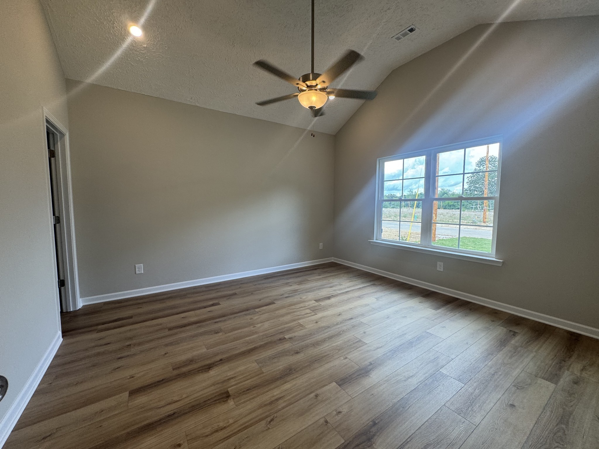 69 Laurel View Street Manchester, TN 37355 - Photo 13 of 15 an empty room with wooden floor chandelier fan and windows