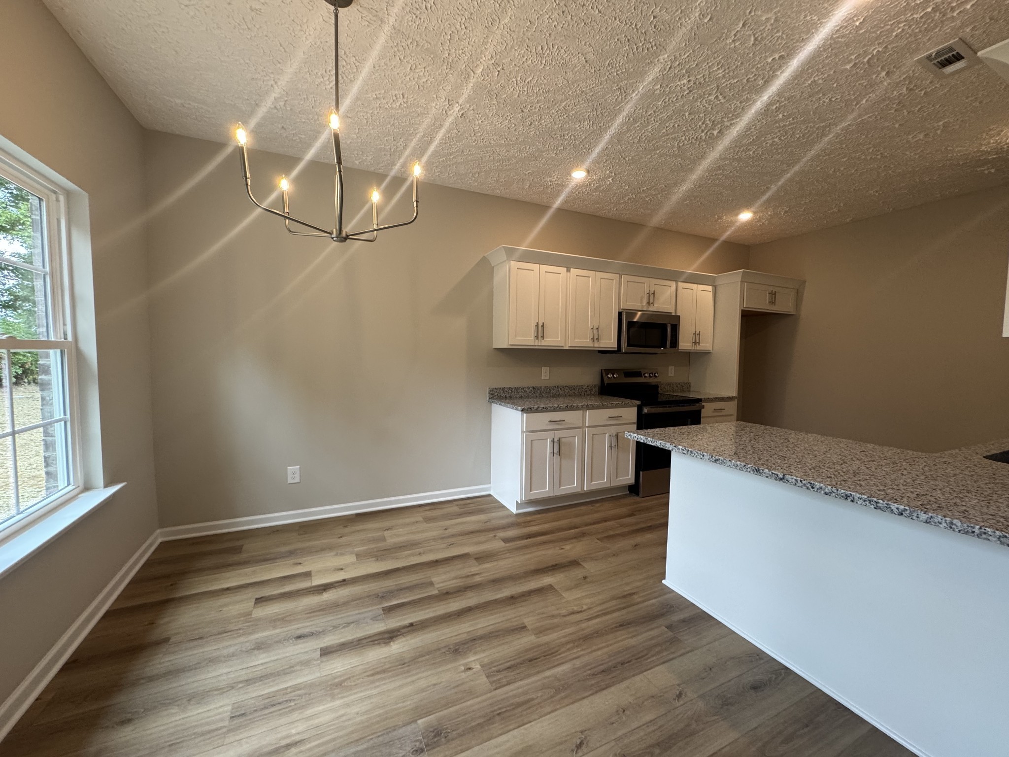 69 Laurel View Street Manchester, TN 37355 - Photo 7 of 15 a large kitchen with kitchen island a stove a sink and a microwave