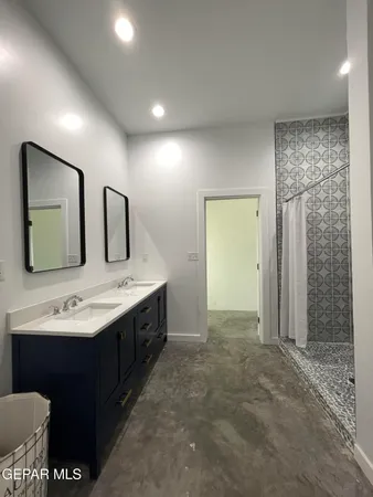 a bathroom with a double vanity sink mirror and shower