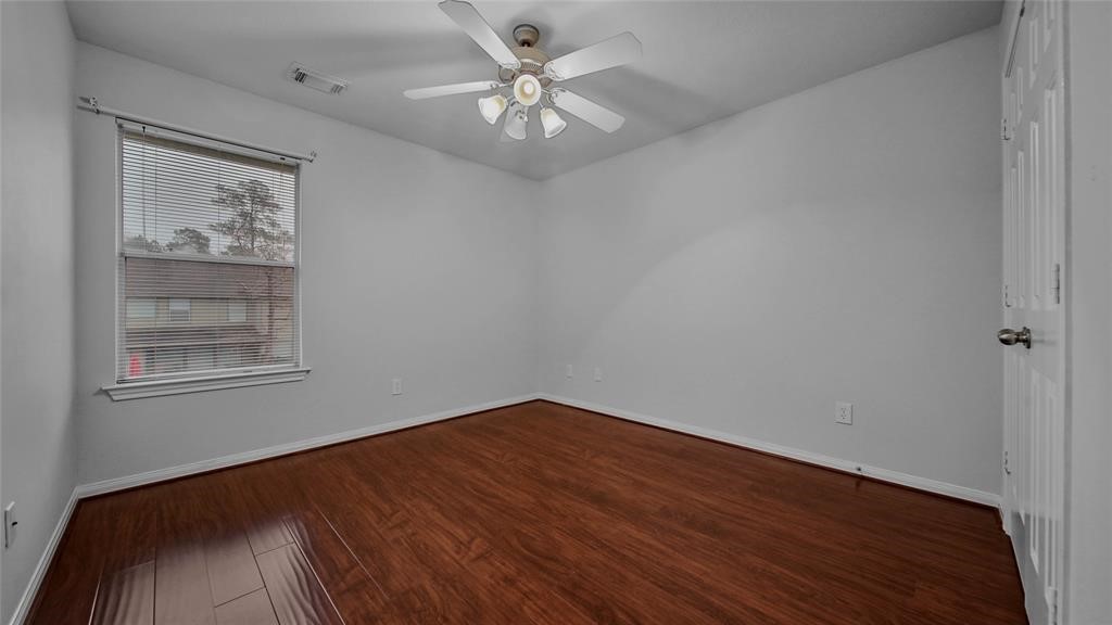 87 West Twinvale Loop Conroe, TX 77384 - Photo 17 of 19 wooden floor in an empty room with a window