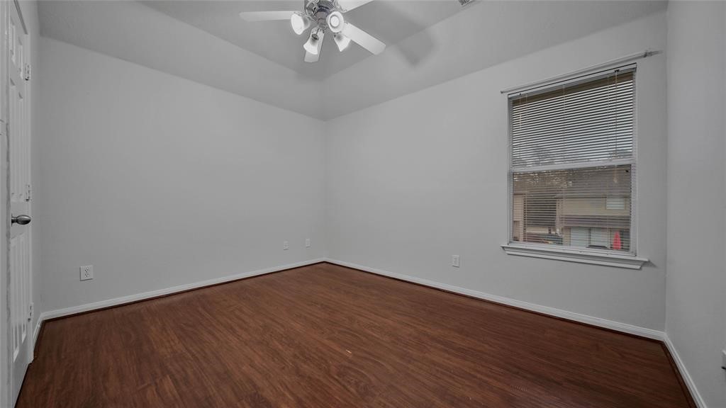 87 West Twinvale Loop Conroe, TX 77384 - Photo 19 of 19 a view of an empty room with wooden floor and a window