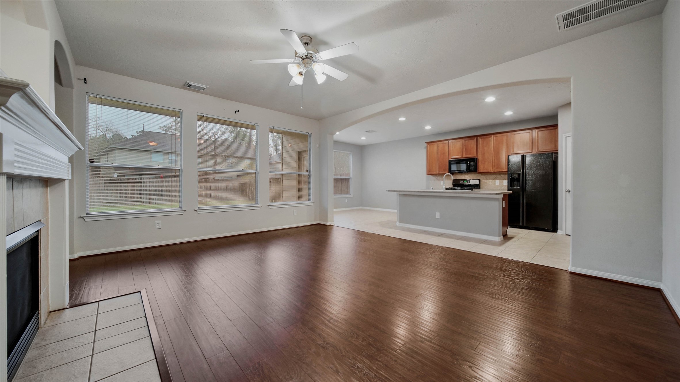 87 West Twinvale Loop Conroe, TX 77384 - Photo 7 of 19 a view of empty room with wooden floor and kitchen view