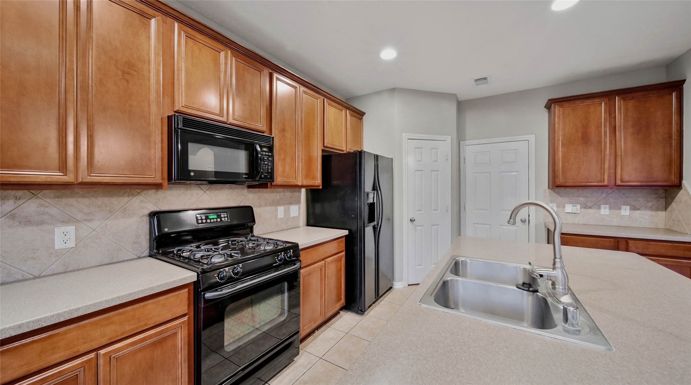 87 West Twinvale Loop Conroe, TX 77384 - Photo 8 of 19 a kitchen with stainless steel appliances granite countertop a stove a sink and a microwave