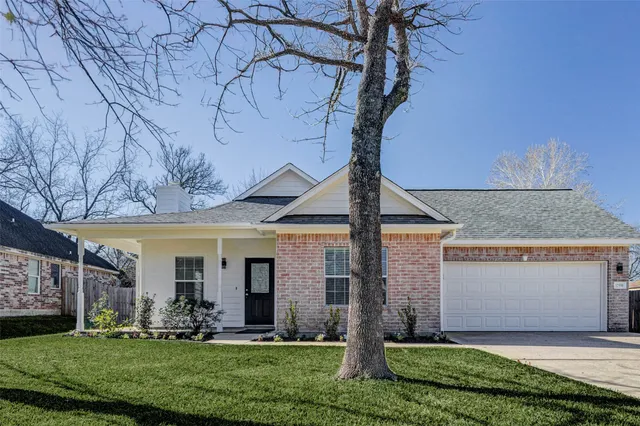 a front view of a house with a yard and trees