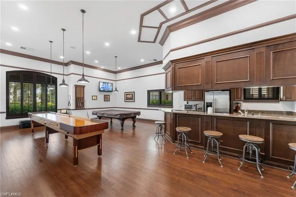 a living room with stainless steel appliances kitchen island granite countertop furniture and a wooden floors