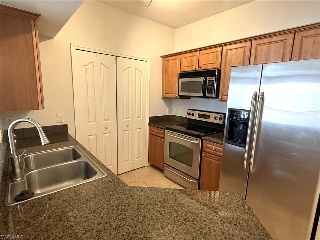 12990 Positano Circle, Unit 208 Naples, FL 34105 - Photo 4 of 20 a kitchen with a refrigerator sink and stove
