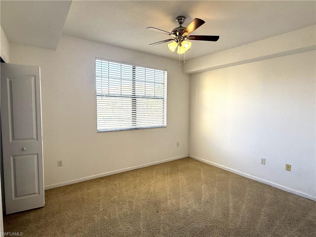 12990 Positano Circle, Unit 208 Naples, FL 34105 - Photo 8 of 20 an empty room with a window and a ceiling fan