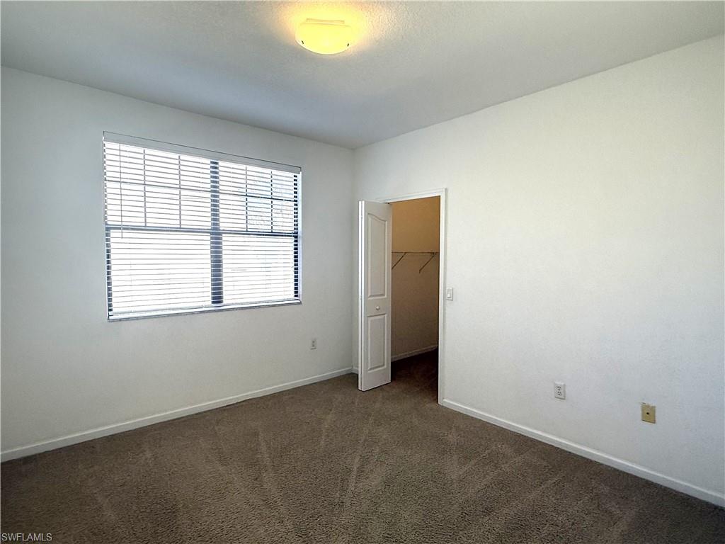 12990 Positano Circle, Unit 208 Naples, FL 34105 - Photo 9 of 20 an empty room with windows