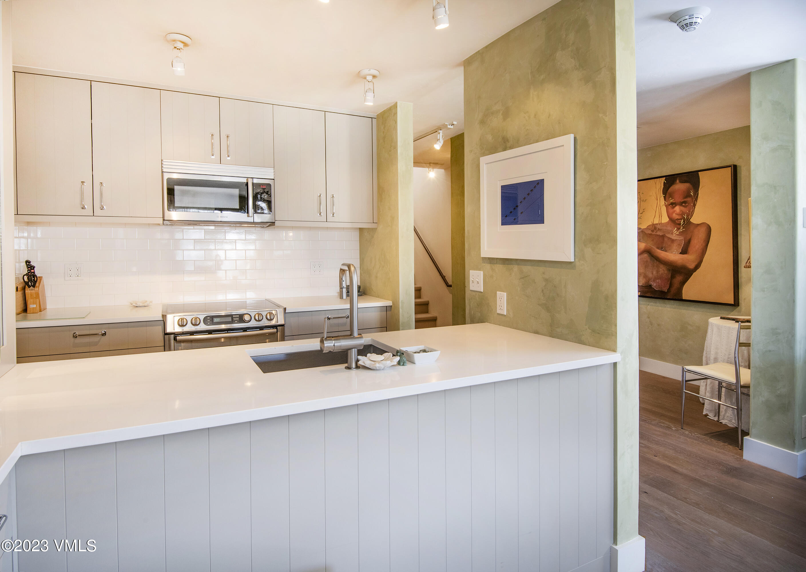 137 Benchmark Road, Unit 327 Avon, CO 81620 - Photo 11 of 43 a kitchen with stainless steel appliances a sink a stove a microwave a sink and cabinets