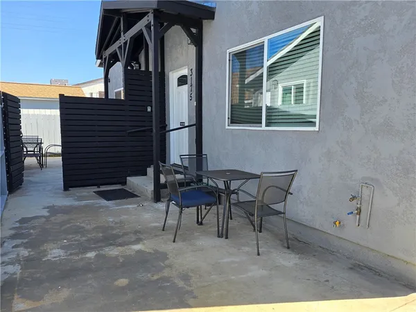 a view of a patio with table and chairs and potted plants with wooden floor