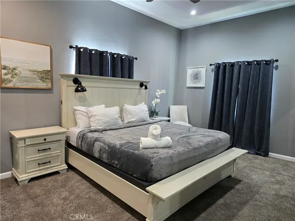 a living room with furniture kitchen area and a wooden floor