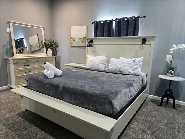 a bedroom with a bed and painting on the wall