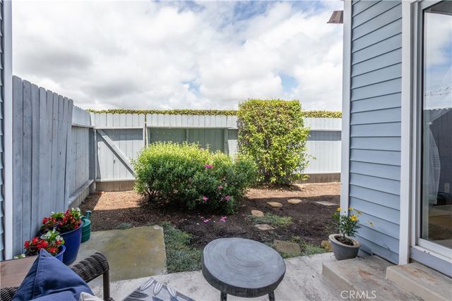 a backyard of a house with fountain table and chairs plants