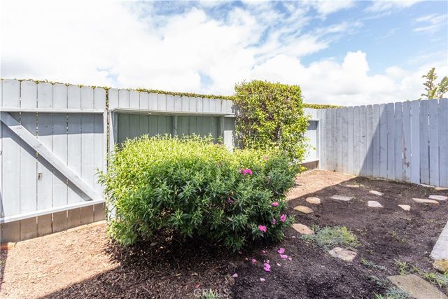 a backyard of a house with a garden and outdoor seating