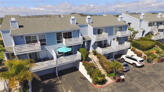 a view of a patio with table and chairs potted plants and large buildings