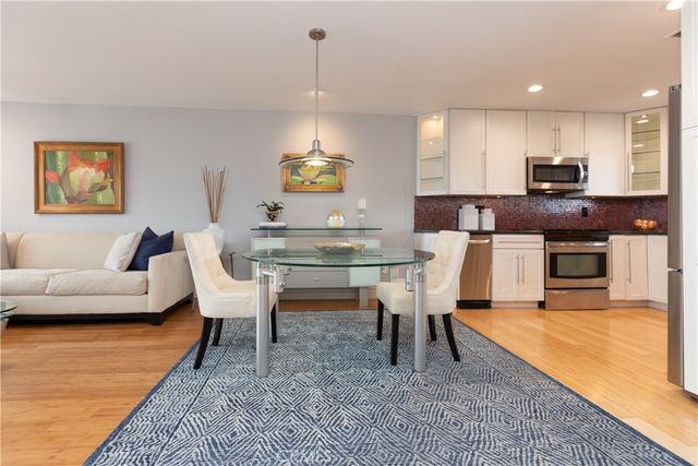 a living room with furniture a rug kitchen view and a fireplace