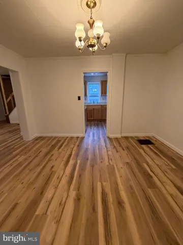 a view of a room with wooden floor and a sink