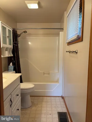 a bathroom with a double vanity sink mirror and toilet