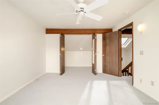 an empty room with a ceiling fan and a window