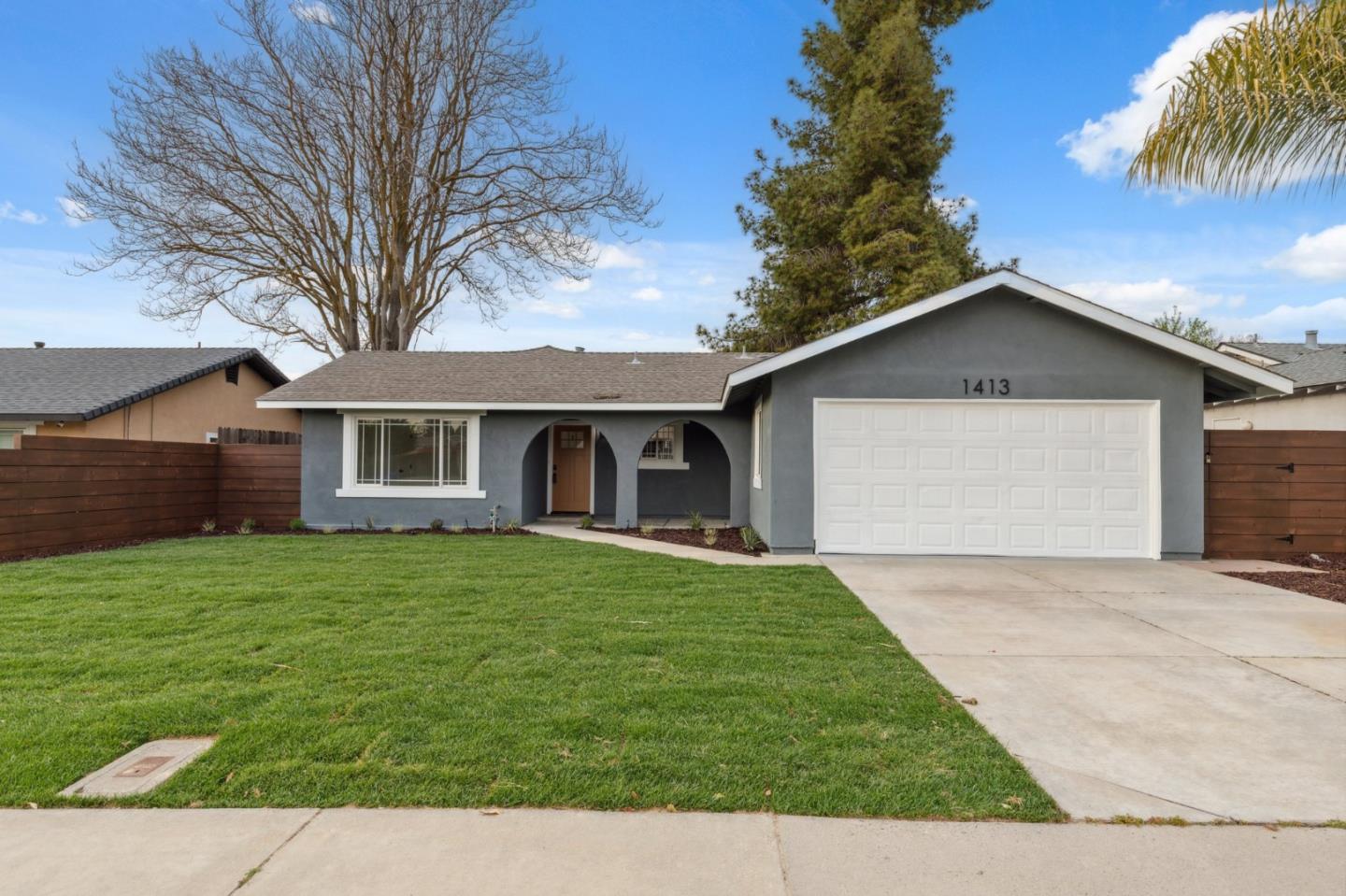 1413 Clevenger Drive Modesto, CA 95356 - Photo 1 of 37 a front view of a house with a garden